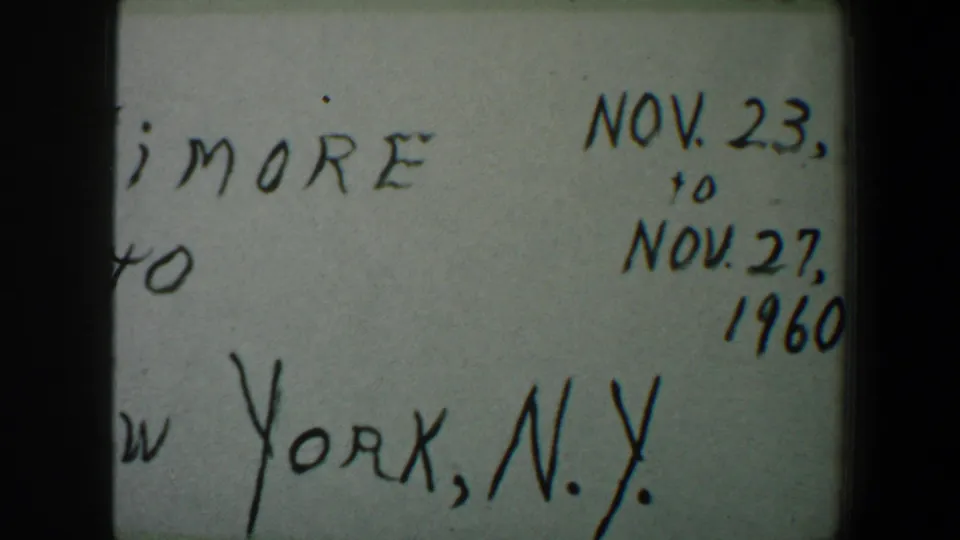 1960 8mm frame of the handwritten travel note, showing partial New York, N.Y. text and November date markings on the right side.
