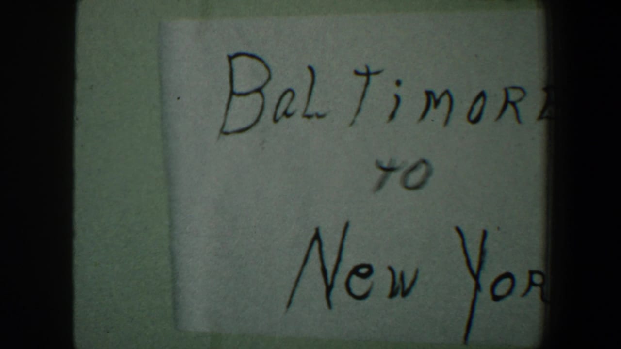 Handwritten card reading Baltimore to New York, partly cropped in an 8mm frame.