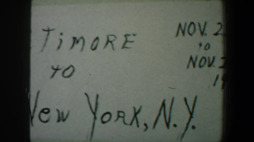 Part of the handwritten travel card shows New York, N.Y. and November date notes, cropped within the 8mm frame.