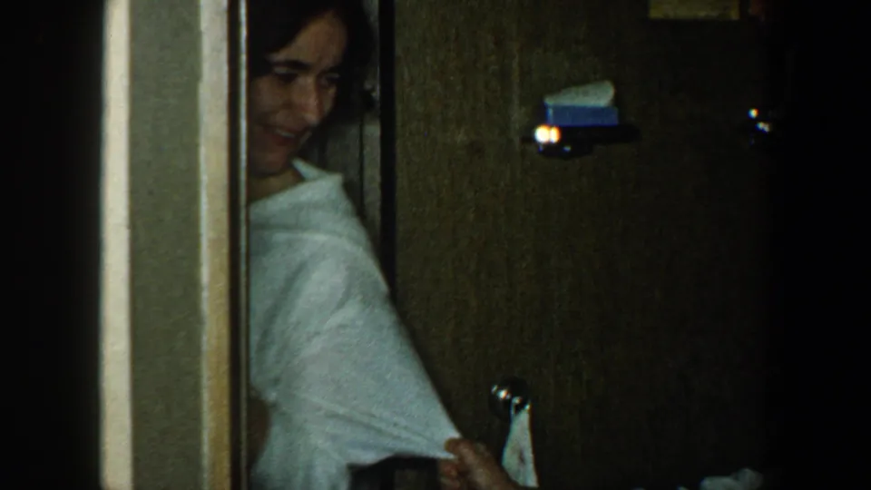 A woman in a light shirt appears in a dim interior near a doorway at the end of the 1960 travel clip.
