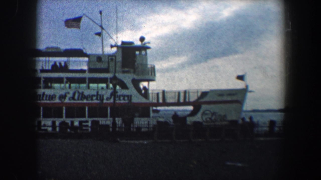 White Statue of Liberty Ferry at a dock with flags, railings, and dark film borders.
