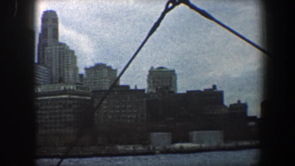 1960 boat-view footage of New York City buildings, with rigging crossing the skyline and river in the foreground.