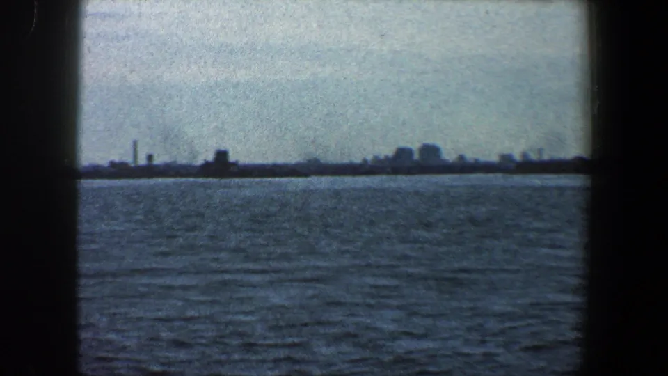 Distant New York City waterfront horizon in 1960, with open water in front and faint buildings along the skyline.