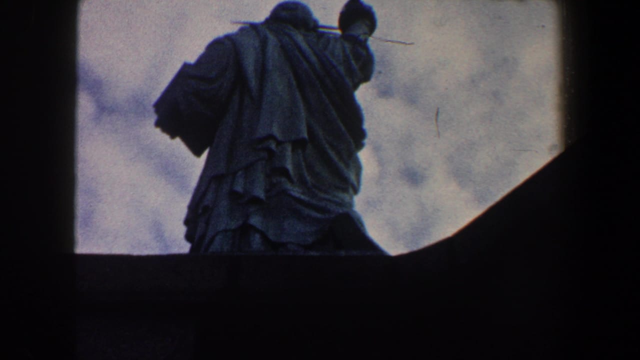 Close rear view of the Statue of Liberty with torch arm near the top edge.