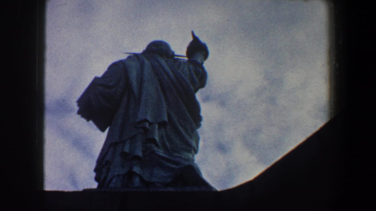 Low-angle view of the Statue of Liberty against a cloudy sky.