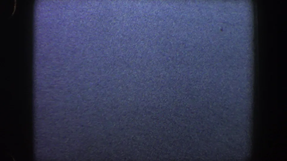 Muted 8mm frame with faint water-and-sky separation, heavy grain, and little identifiable landscape detail.