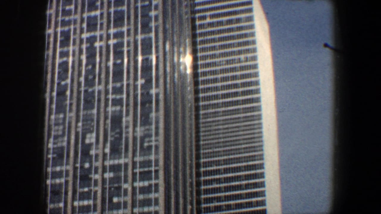 Tall glass office towers seen from below, with a streetlight near the lower edge.