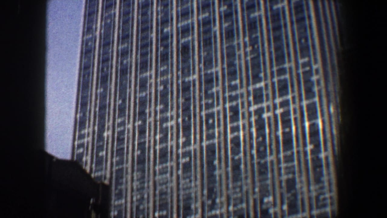 Close upward view of a high-rise facade with vertical window bands.