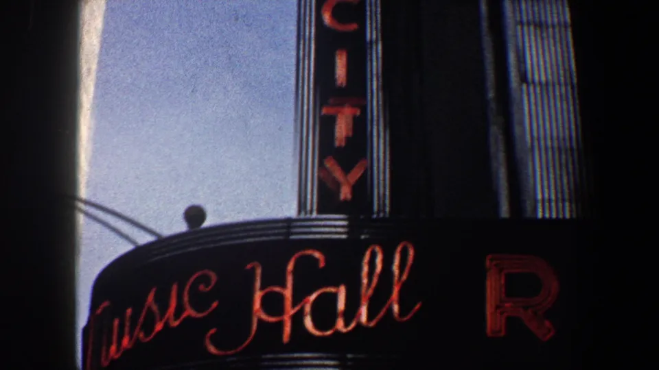 Radio City Music Hall marquee in New York City, with red script lettering and the vertical sign partly visible above.