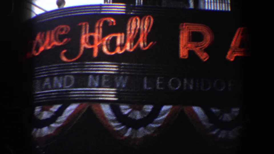 Closer 1960 view of the Music Hall marquee, with red neon script, partial marquee text, and bunting along the lower edge.