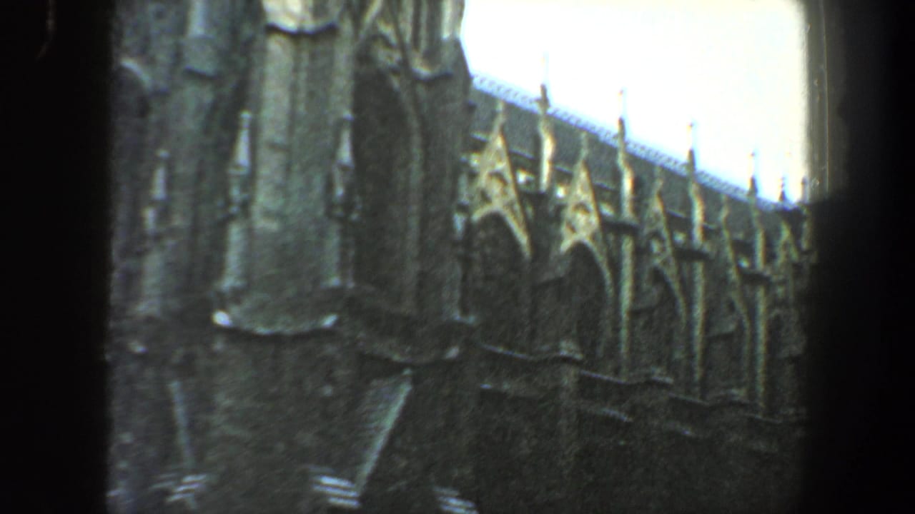 Ornate arched building facade seen through a dark vertical frame.