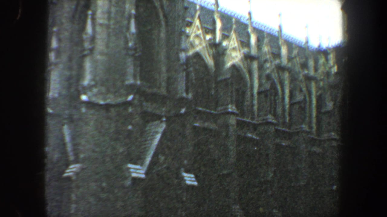 Dark-framed view of an ornate building wall with arched details.
