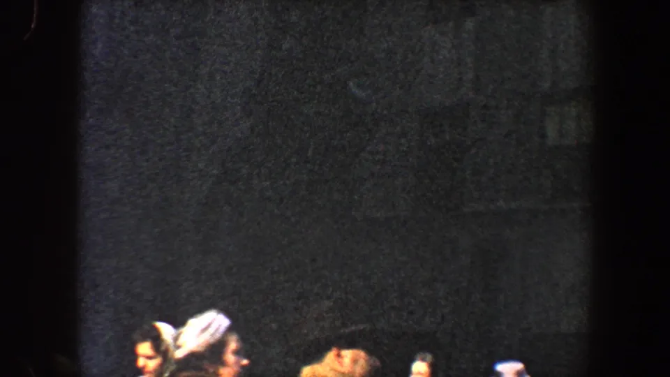 1960 New York City home-movie frame showing partial pedestrians along the bottom of a dark, grainy street scene.