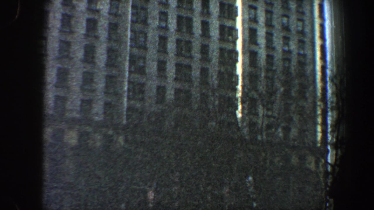 Tall building exterior partly obscured by a dark vertical film edge.