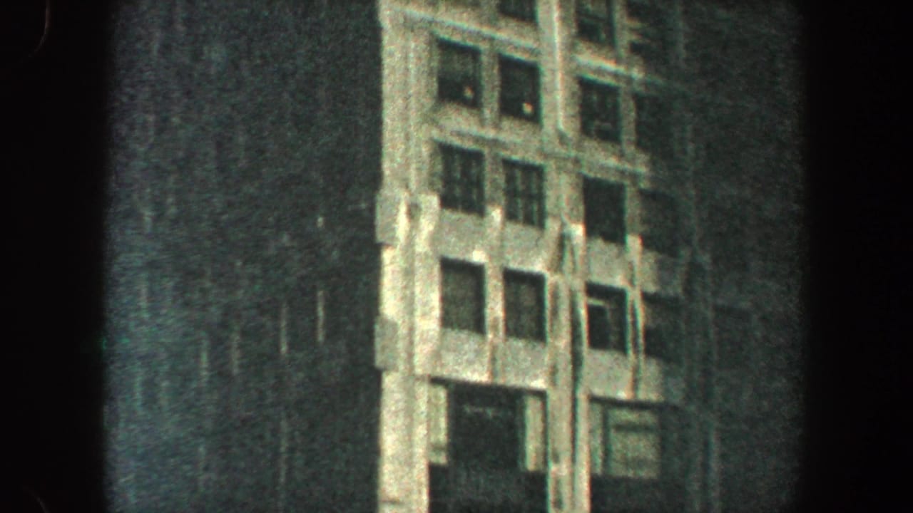 Low-angle view of a tall skyscraper facade with dark film borders.