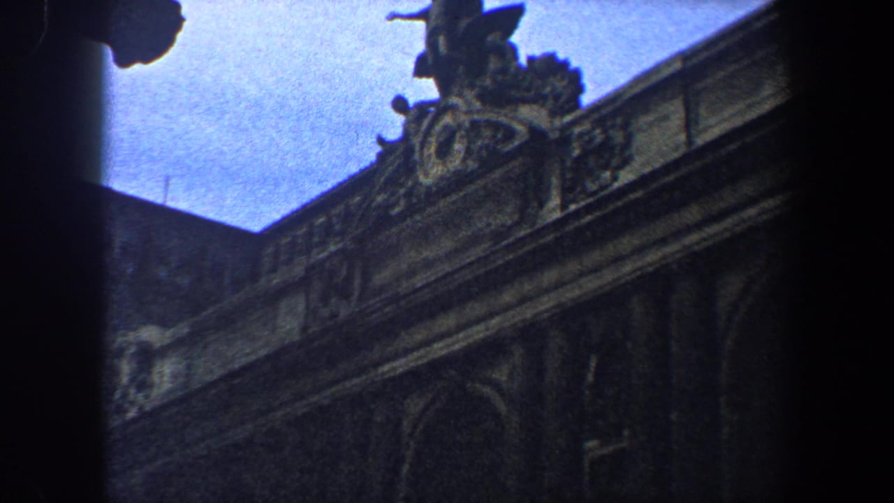 Ornate upper facade with sculptural roof detail and dark vignetted film edges.