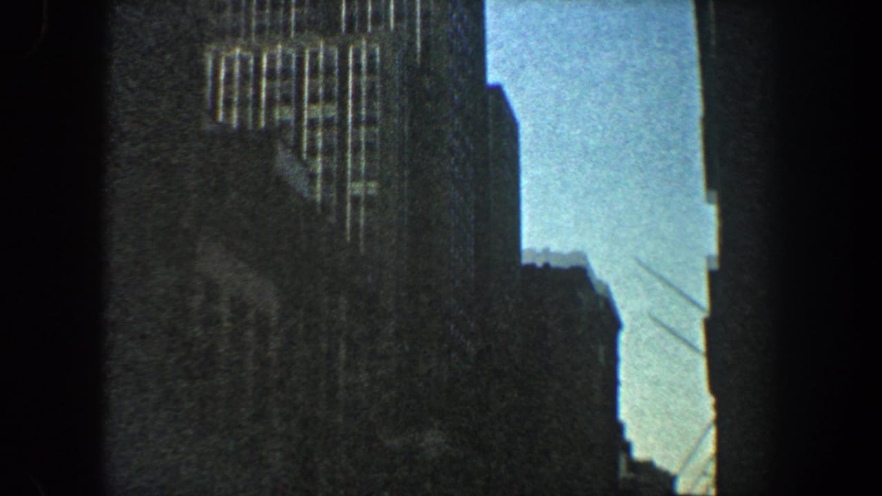 Low-angle view between dark city buildings with a bright sky gap.