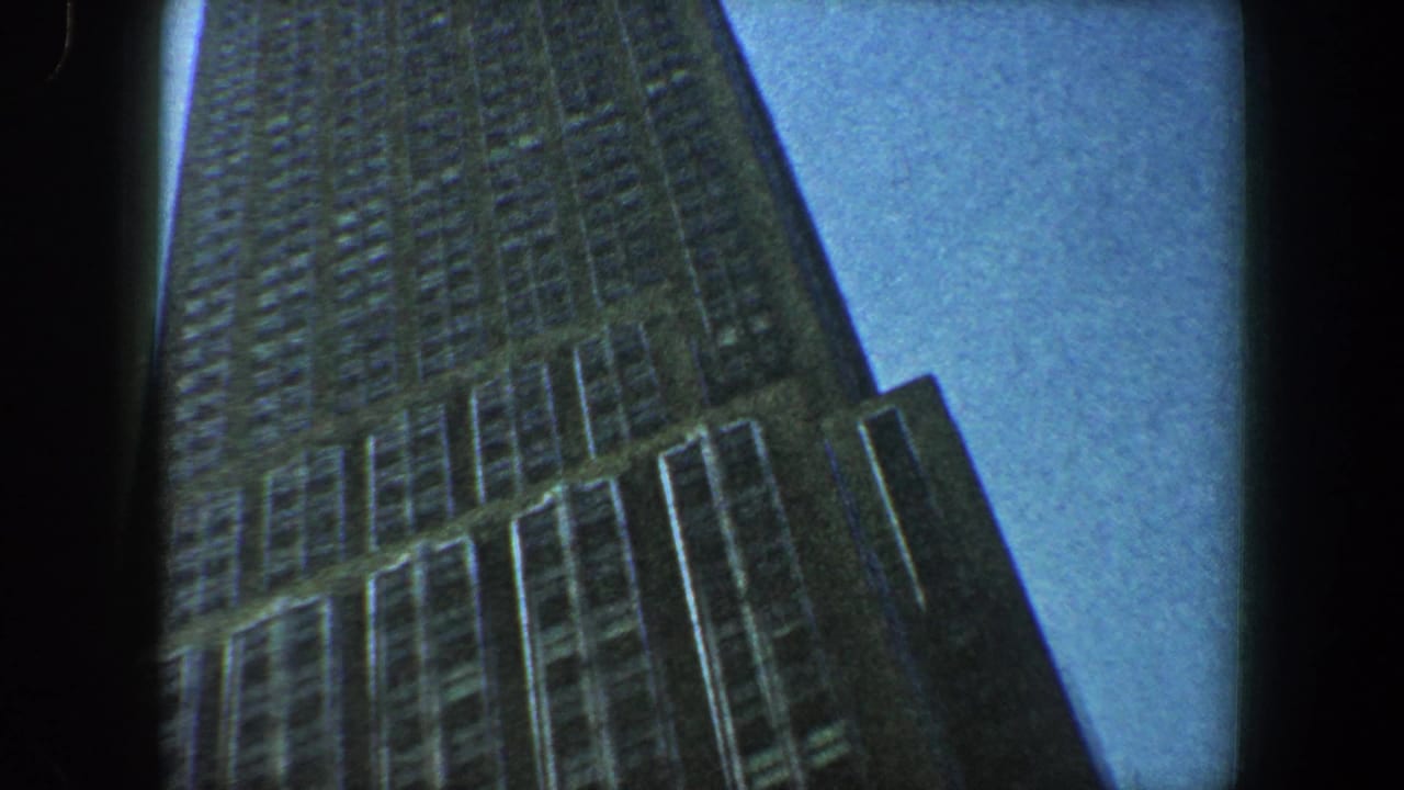 Upward-looking frame of the skyscraper facade with rows of windows.