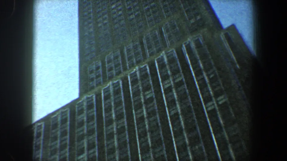 1960 New York City 8mm frame with the Empire State Building filling most of the view during an upward tilt.