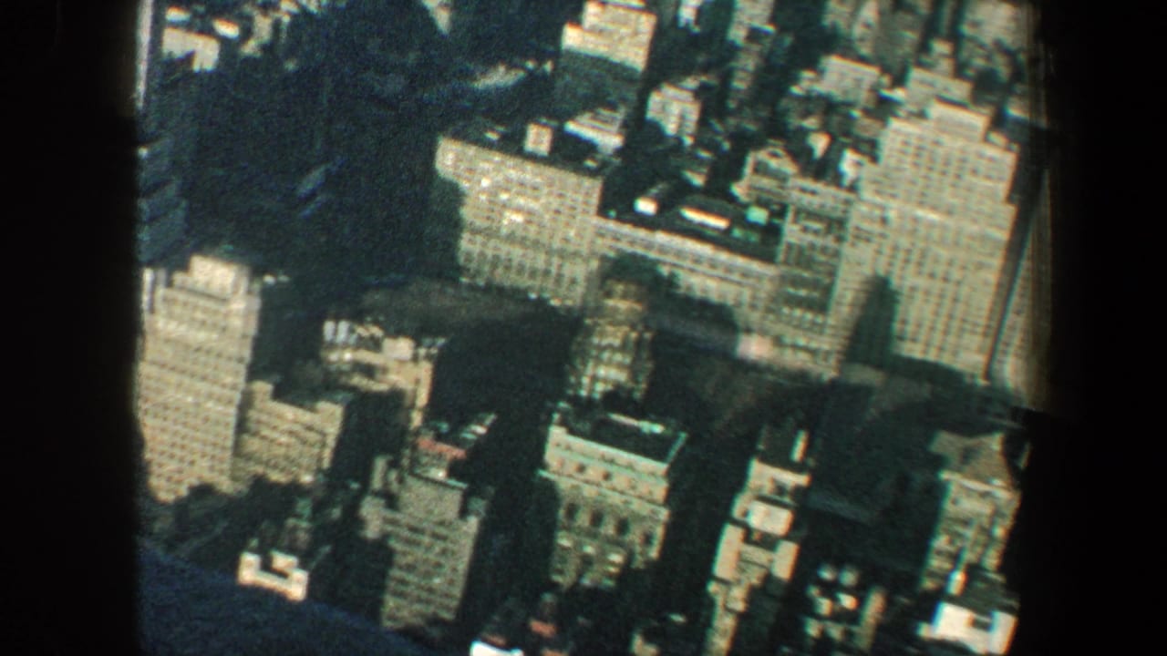 Aerial view of tall city buildings with dark vertical obstruction in foreground.