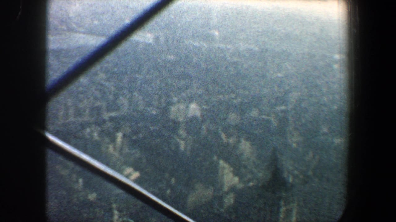 Dense urban landscape viewed through a window with crossing beams.