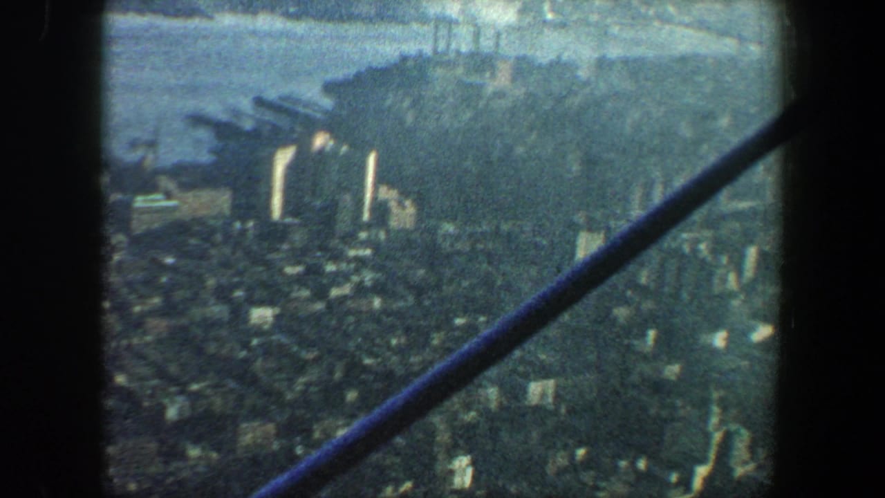 Elevated urban view with waterfront, high-rises, and crossed structural beams.