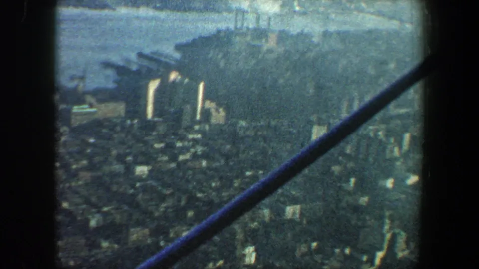 1960 New York City aerial-style frame with high-rises near the waterfront and dark beams cutting across the view.