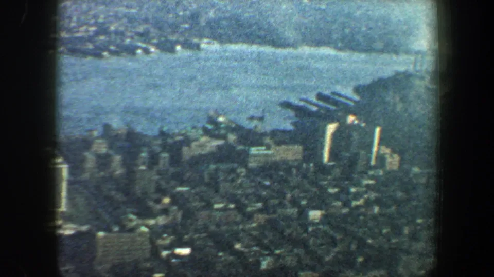 1960 New York City home-movie view of dense waterfront buildings, piers, and water from a high overlook.