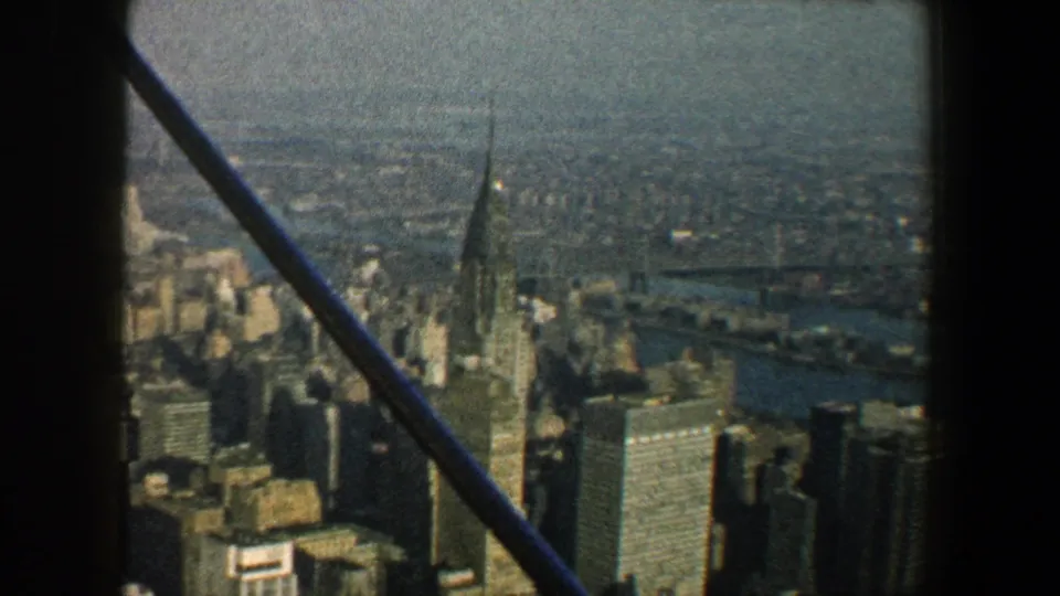 1960 New York City skyline with the Chrysler Building centered behind diagonal iron bars and soft 8mm texture.