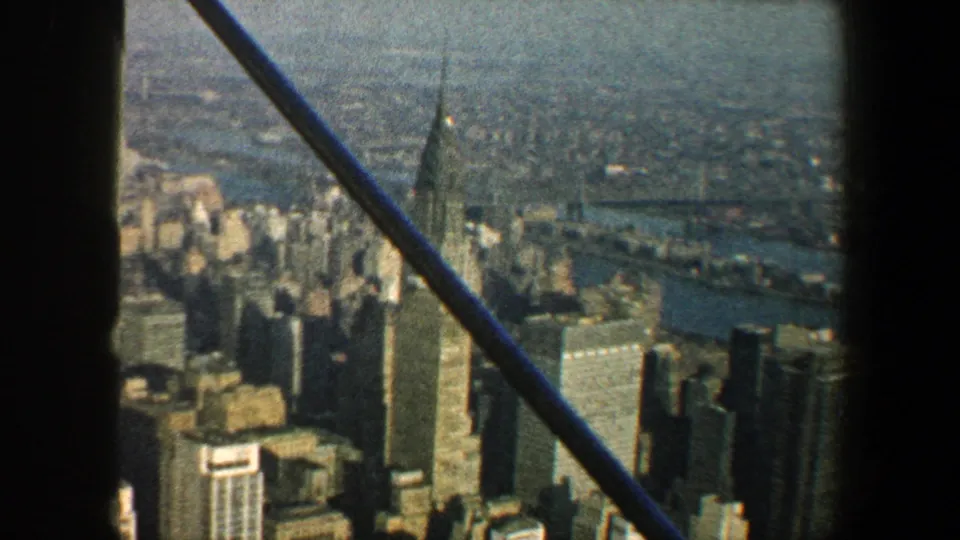 A high 1960 New York City view shows the Chrysler Building and surrounding towers behind dark vertical and diagonal foreground bars.