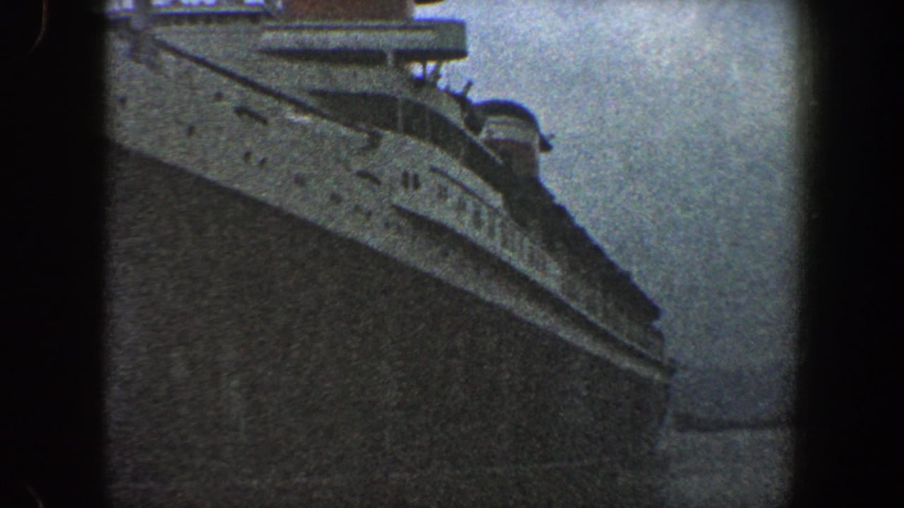 Large passenger ship hull seen from a low angle with upper decks near the top of frame.