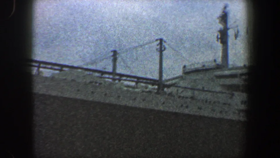 1960 New York City harbor footage showing the upper decks, mast and railings of a large ocean liner under an overcast sky.