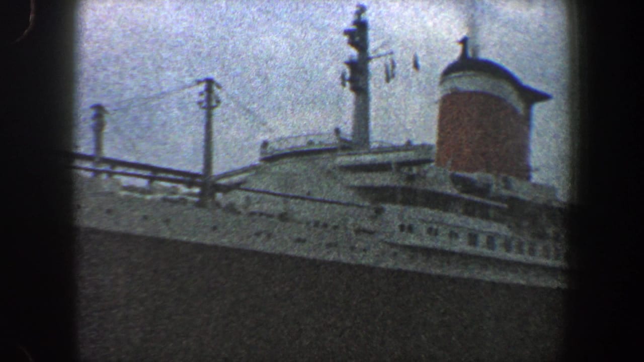 Ocean liner superstructure with mast, railings and a red funnel near the right edge.