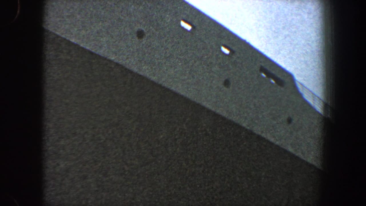 Large vessel hull seen from below with small light openings near the top edge.