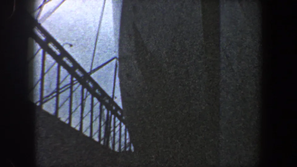 1960 New York City 8mm view of bridge construction details, with a railing, diagonal cables, concrete support, and dark vignetting.