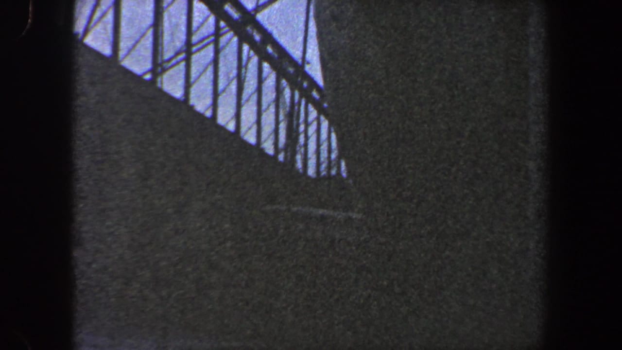 Close view of a ship side with railings and a dark vertical film edge.