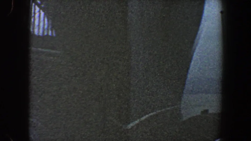 1960 New York City 8mm frame showing a low-angle bridge construction view with dark supports and steel framework overhead.