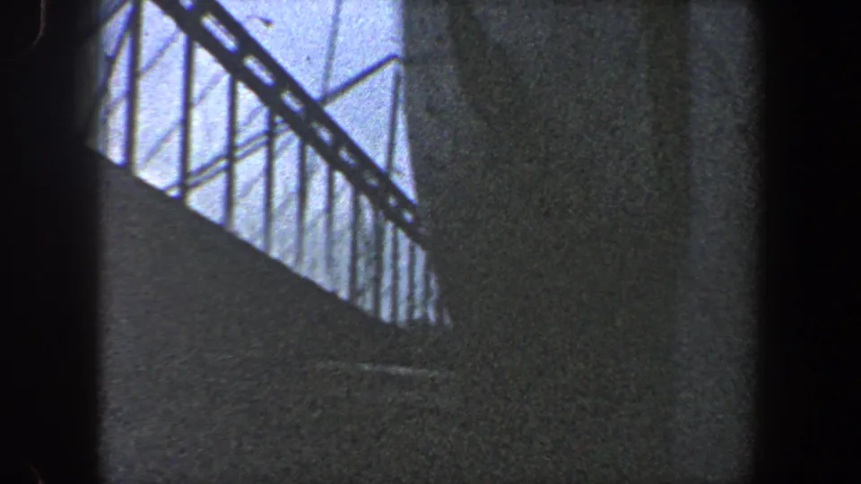 1960 New York City 8mm frame looking up at steel bridge trusses and heavy shadowed supports during construction.
