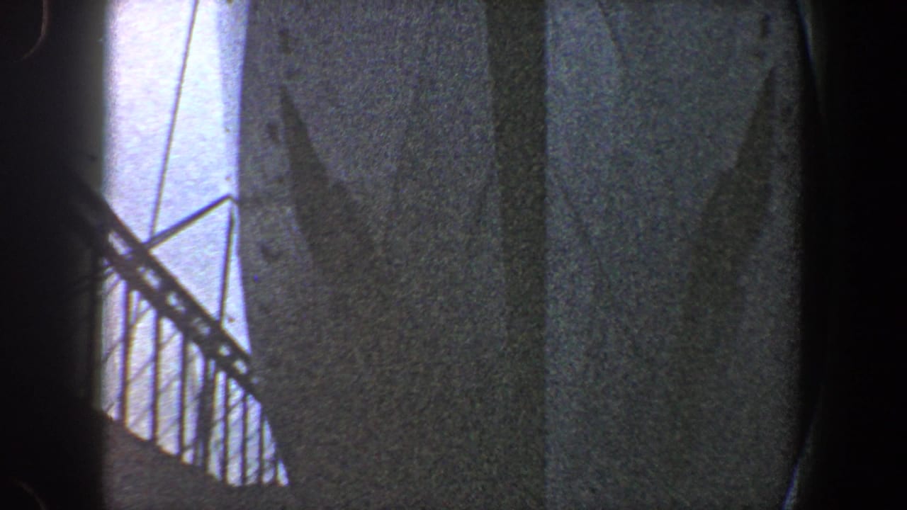 Shadowed bridge structure with diagonal truss lines and a bright strip of sky.