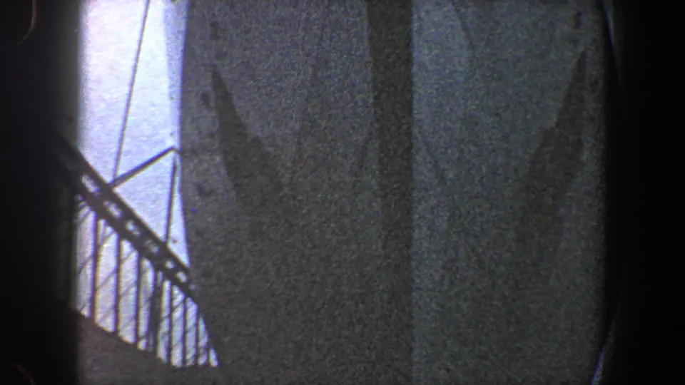 1960 New York City 8mm frame showing a shadowed bridge under construction with diagonal steel bracing and pale sky.