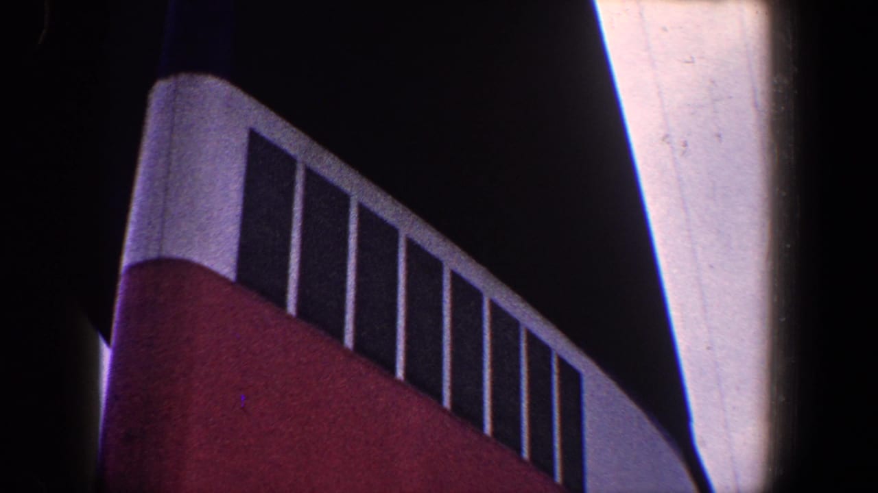 Close view of red structure topped by white railings against a dark background.