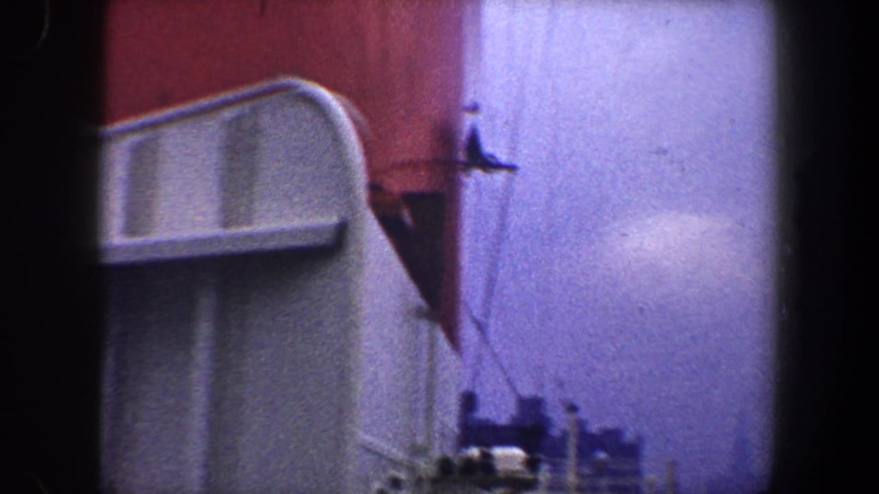 Red-and-white ship structure beside a dark vertical frame edge and pale sky.
