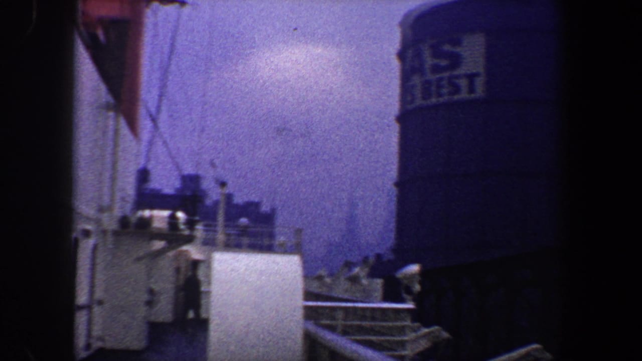 Ship deck area with a blue water tank bearing visible lettering at right.