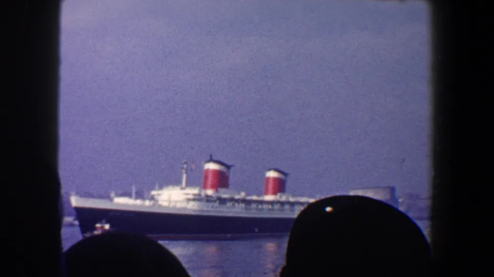 A 1960 New York City harbor shot shows the Queen Mary across the water, partially obscured by foreground spectators and a window edge.