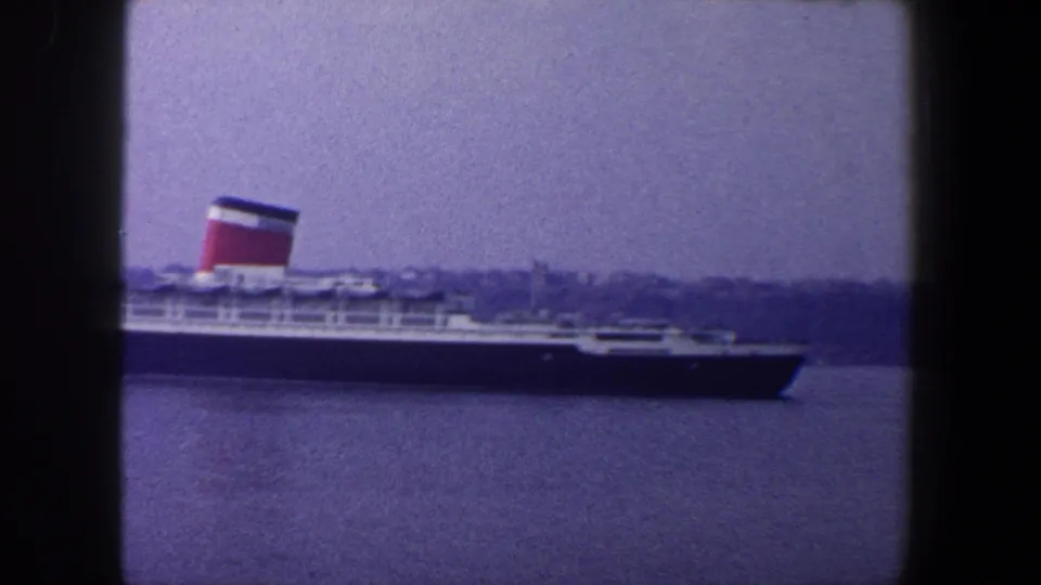 1960 New York City harbor footage showing the Queen Mary broadside through a window-framed view.