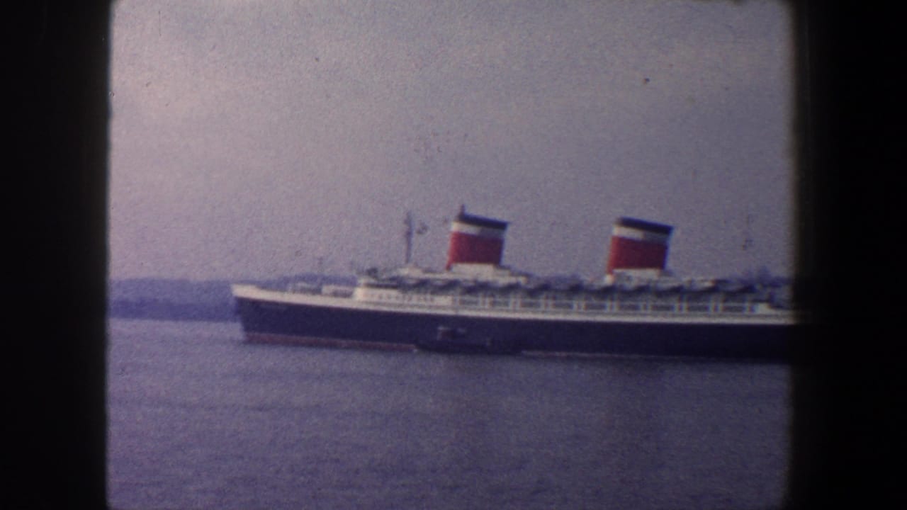 Side view of a large ocean liner with red funnels partially framed by dark film borders.