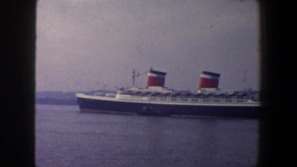 1960 New York City archival frame with a twin-funnel passenger liner seen in side profile on the water.