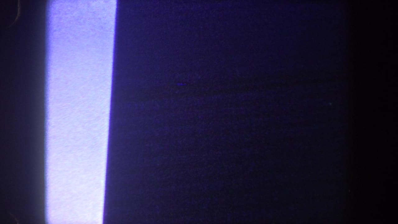 Dark vertical shapes with a bright overexposed strip at the left edge.
