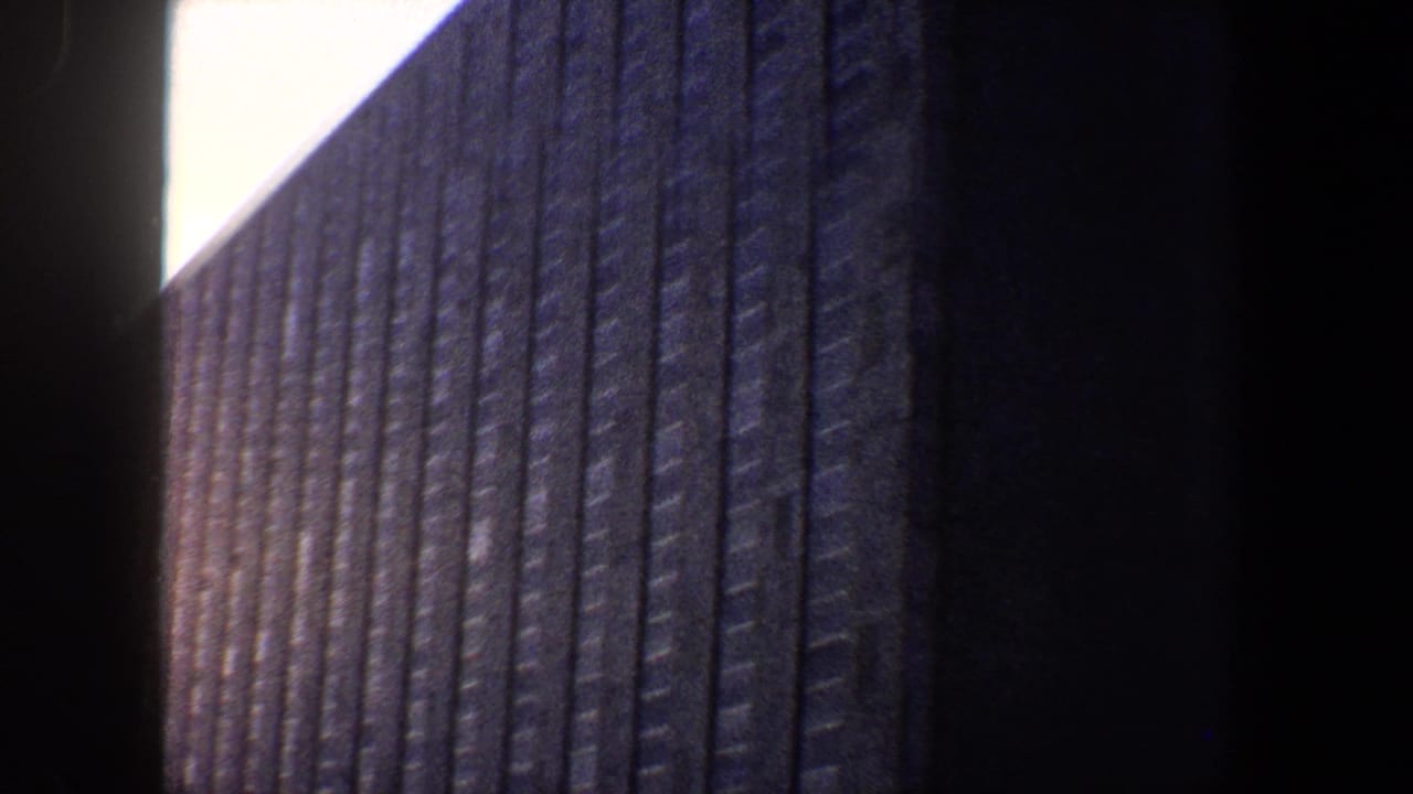 Tall ribbed building wall seen from below with a dark edge at right.