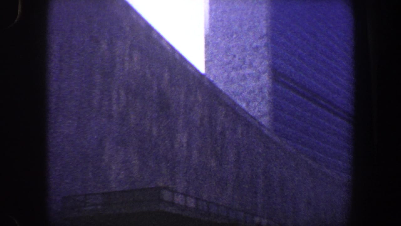 Tall facade with vertical edges and a small rail-like detail near the lower right.